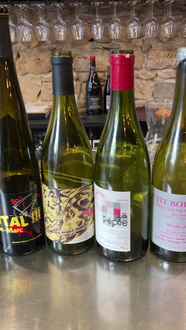 Une bouteille de vin naturel sous des verres suspendus