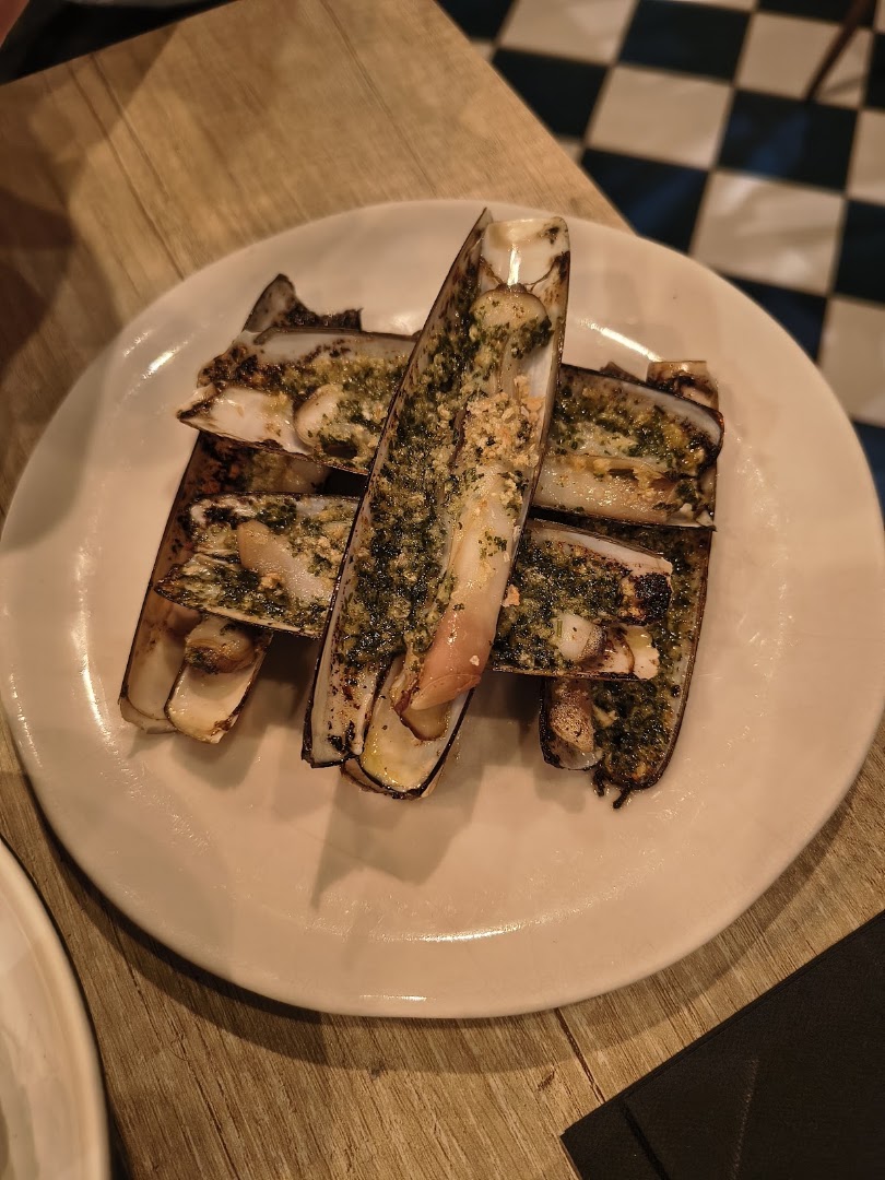 Des couteaux de mer grillés et garnis d’herbes